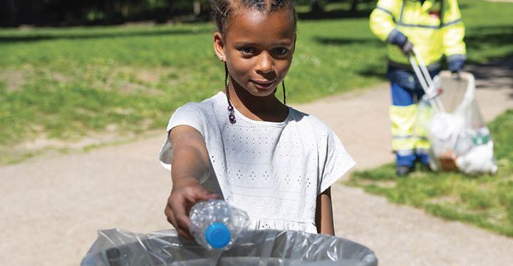 Une jeune Bagnoletaise jette une bouteille plastique dans une corbeille de rue