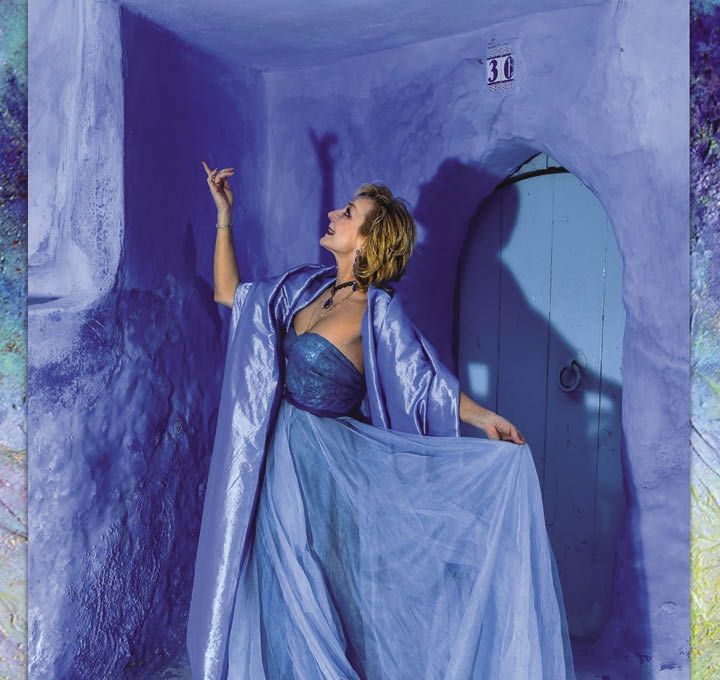 Larissa Noury porte sa création devant un de ses tableaux