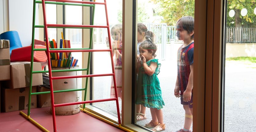 Des enfants observent leur classe derrière la fenêtre