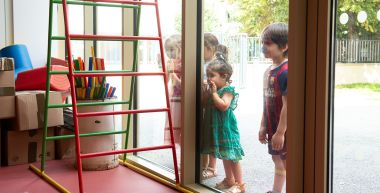 Des enfants observent leur classe derrière la fenêtre