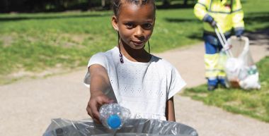 Une jeune Bagnoletaise jette une bouteille plastique dans une corbeille de rue