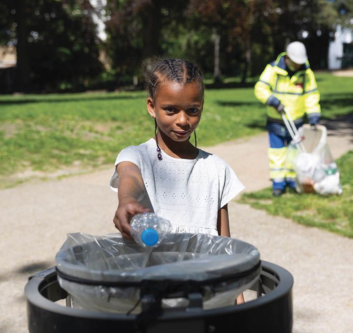Une jeune Bagnoletaise jette une bouteille plastique dans une corbeille de rue