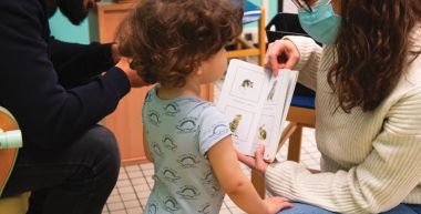 A la PMI, lecture expliquée à un enfant accompagné de son père